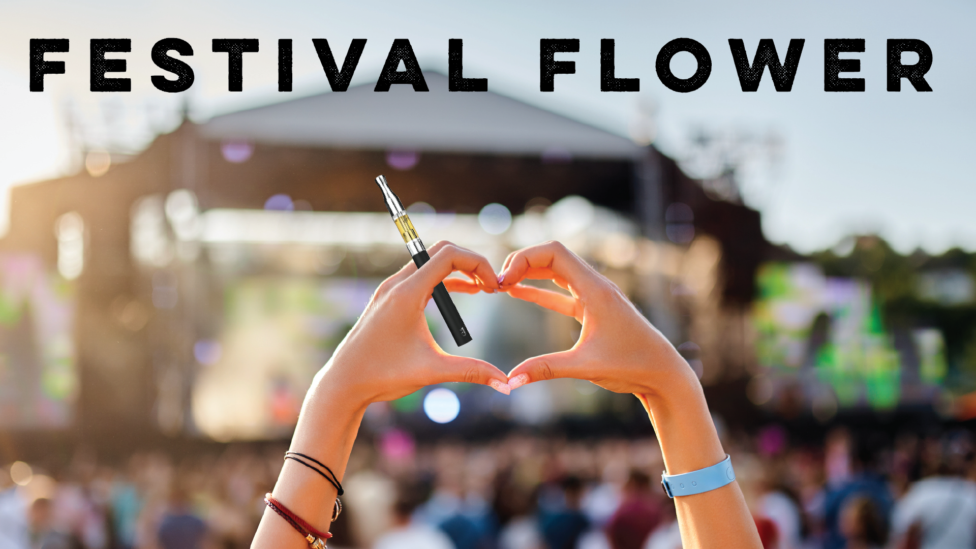 Festival Flower: Festival auditorium with a concertgoer forming a heart with their hands while holding a vape May 1 Blog Image