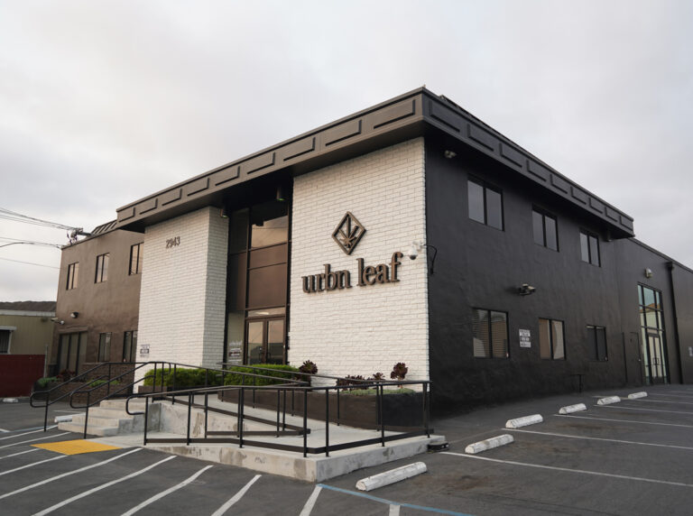 San-Jose-Urbn-Leaf-California-Cannabis-Dispensary-Exteriorjpg - Harborside A modern two-story building with a black and white exterior displays the "urbn leaf" logo near the main entrance, with a wheelchair-accessible ramp and parking spaces in front. San-Jose-Urbn-Leaf-California-Cannabis-Dispensary-Exteriorjpg