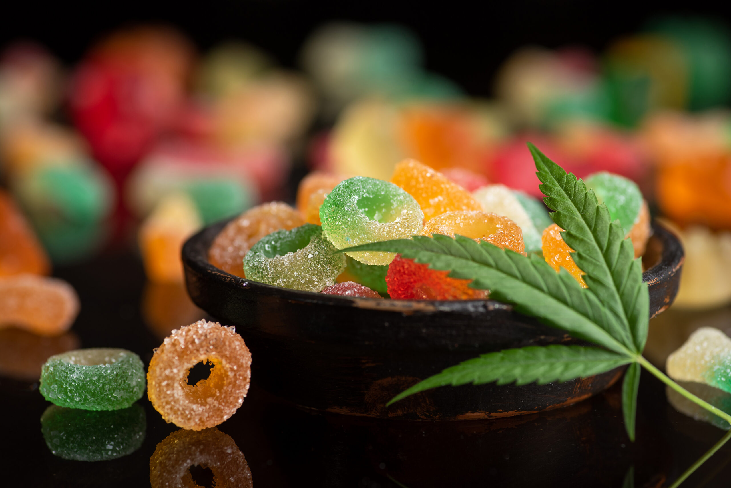 Colored candy gelatin in a black bowl with marijuana leaves - Harborside Not sure which cannabis method is right for you? We’re here to help you explore gummies, vapes, and flower — your way. Colored candy gelatin in a black bowl with marijuana leaves